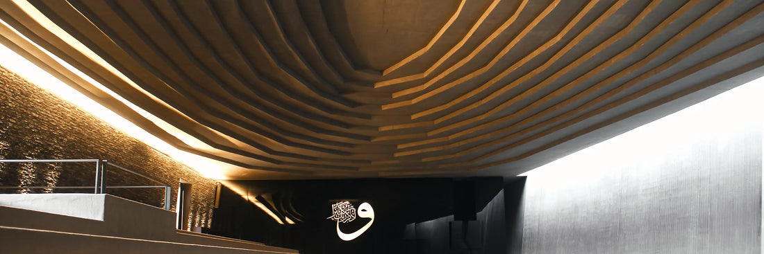 Calligraphie arabe dorée sur une voûte courbe, lumière chaude