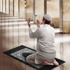 Homme en prière sur le tapis de voyage déplié dans une mosquée