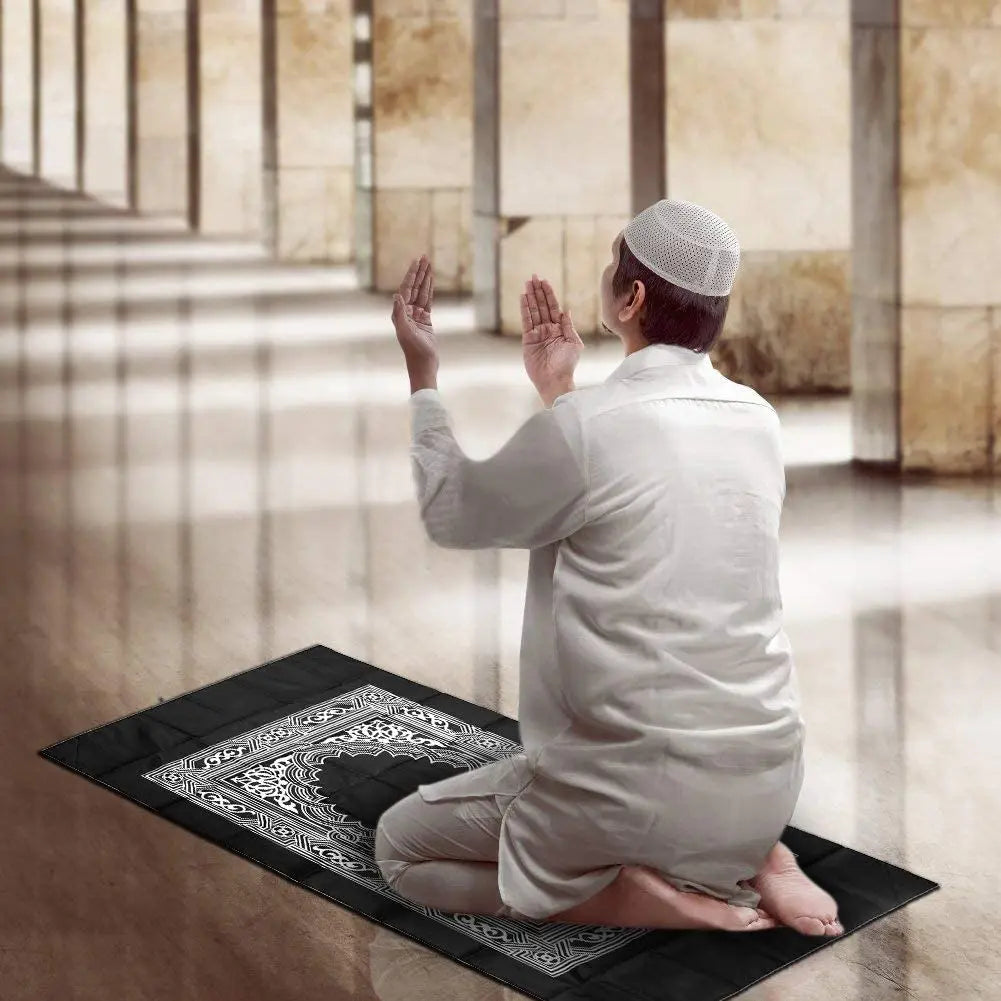 Homme en prière sur le tapis de voyage déplié dans une mosquée
