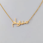Gros plan sur le pendentif prénom en calligraphie arabe doré